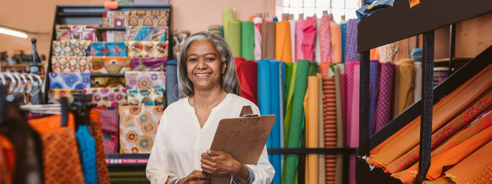 Woman owner of a fabric store holding a clipboard